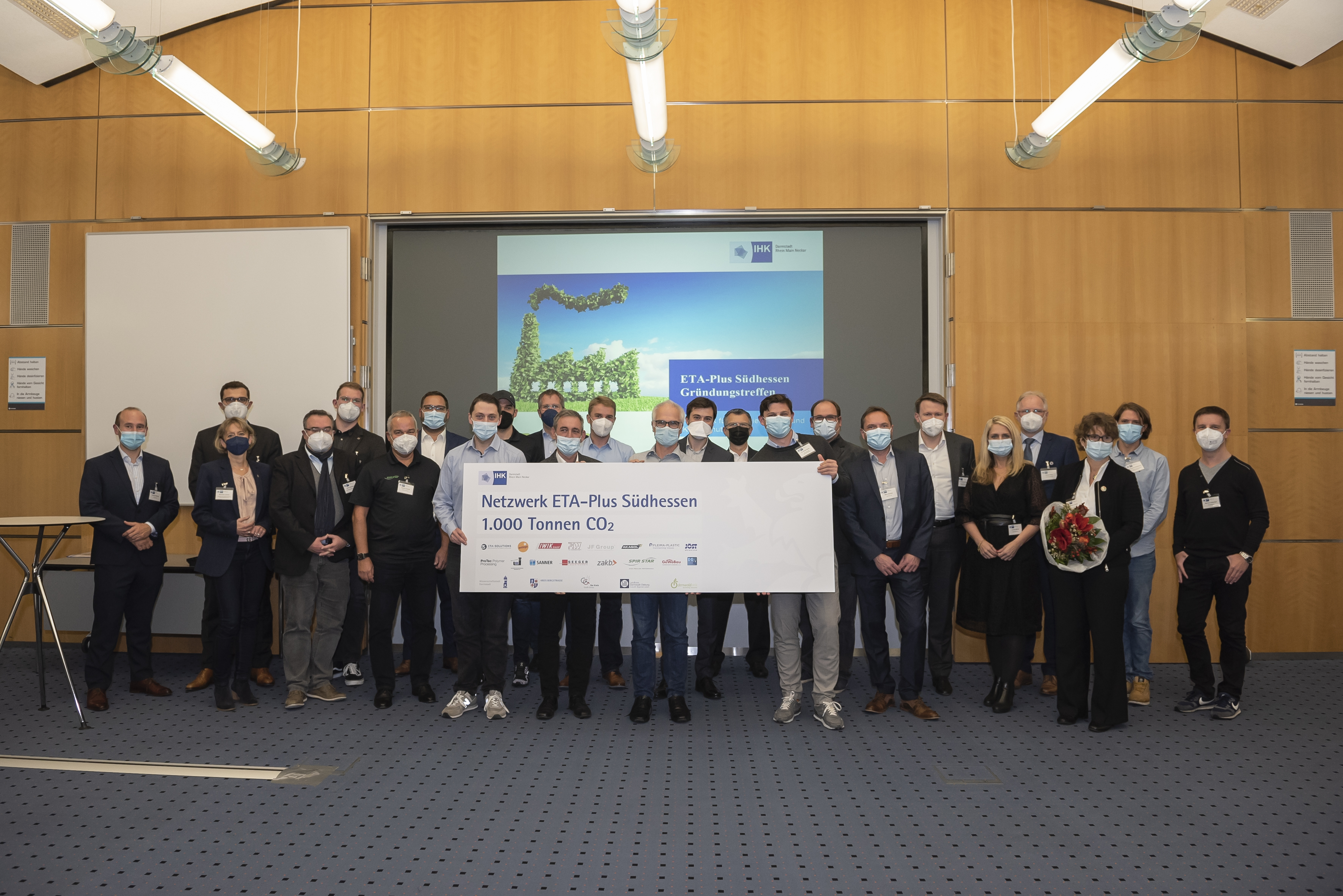 Das Ziel klar vor Augen: Die Mitglieder des Energieeffizienz- und Klimaschutz-Netzwerks ETA-Plus Südhessen wollen in den nächsten zwei Jahren gemeinsam 1.000 Tonnen CO2 einsparen. Foto: Klaus Mai / IHK Darmstadt *ETA steht hier für den griechischen Buchstaben "eta", dieser wiederum für die Energieeffizienz, also für die Effizienz bei der Ausnutzung von Energie. Foto: Klaus Mai / IHK Darmstadt Gruppenfoto der Mitglieder des Energieeffizienz- und Klimaschutznetzwerks ETA-Plus Südhessen halten einen symbolischen Scheck in die Kamera, auf dem steht, dass sie 1.000 t CO2 in den nächsten zwei Jahren einsparen wollen. / Foto: Klaus Mai / IHK Darmstadt